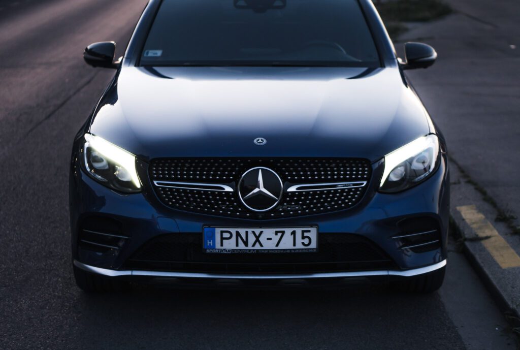 Sötétkék Mercedes-Benz GLC szemből, bekapcsolt fényszórókkal
